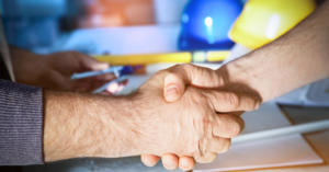 Construction worker shaking hand of newly hired employee